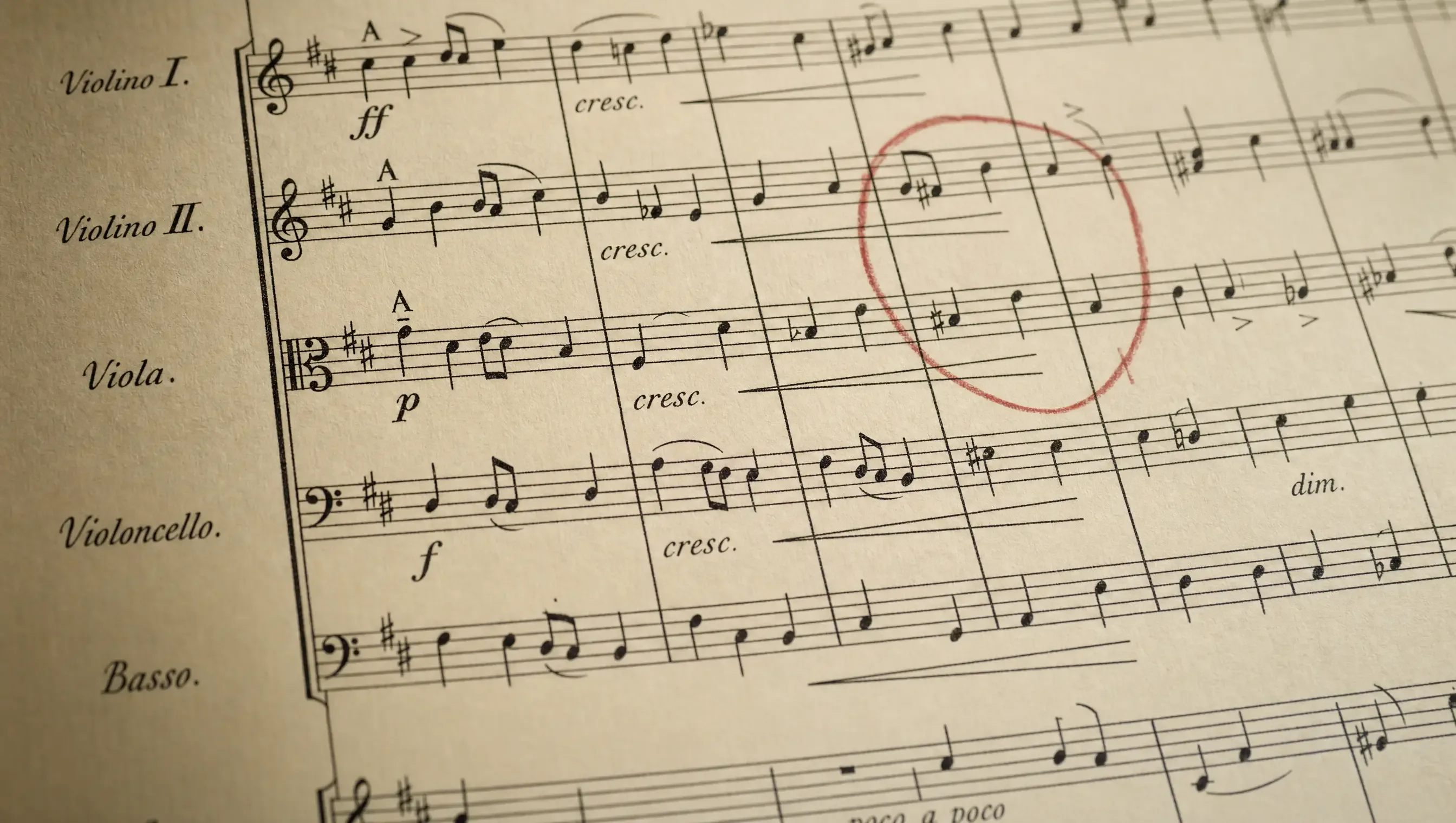Hand-engraved orchestral score on cream paper with a red conductor's pencil mark circling one bar.